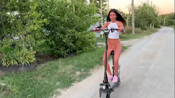 A naked girl rides a scooter through the streets and shocks passers-by naked on public